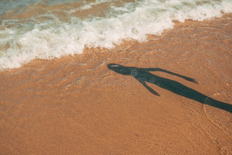 Shadow of a boy on sandy ocean beach in summer royalty free stock images