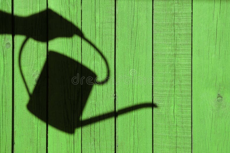 The shadow of a hand with watering can