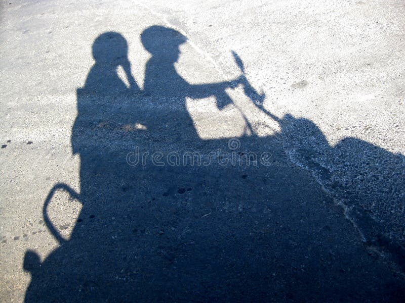 Shadow from a young pair on the motor scooter