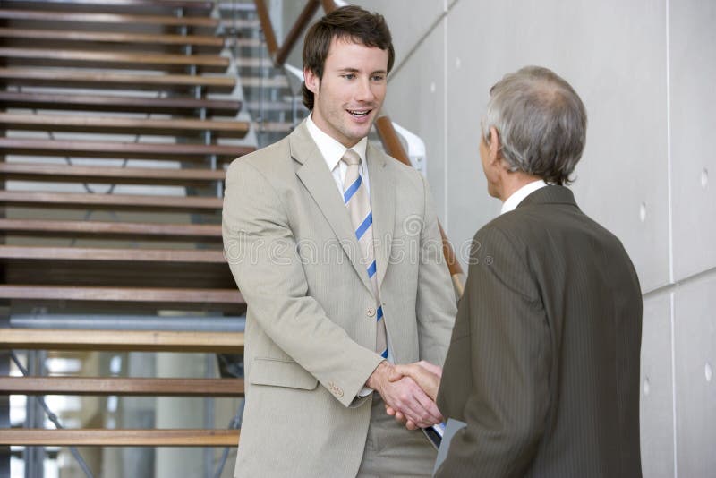 Shaking hands on a staircase stock photography