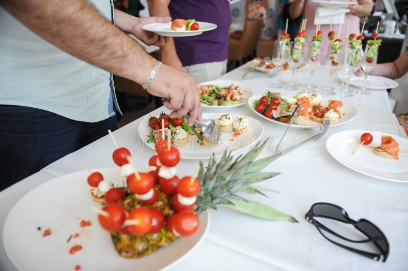Shallow depth of field selective focus image with a man taking aperitifs from an open buffet table royalty free stock photography