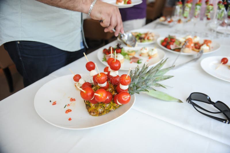 Shallow depth of field selective focus image with a man taking aperitifs from an open buffet table royalty free stock images