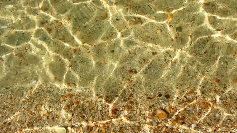 Shallow water caustics and yellow beach sand background texture. stock video footage
