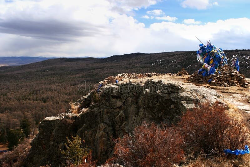 Ovoo with sacred silk scarves on a cliff in Tovkhon Monastery, Ovorkhangai Province, Mongolia. UNESCO World Heritage Site. stock photos Ovoo with sacred silk scarves on a cliff in Tovkhon Monastery, Ovorkhangai Province, Mongolia. UNESCO World Heritage Site. stock photos