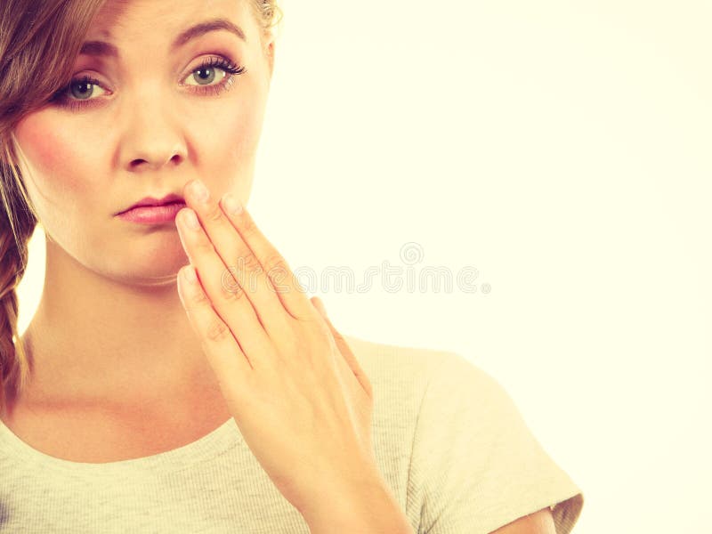 Upset teenage woman with hand close to lips royalty free stock photo Upset teenage woman with hand close to lips royalty free stock photo