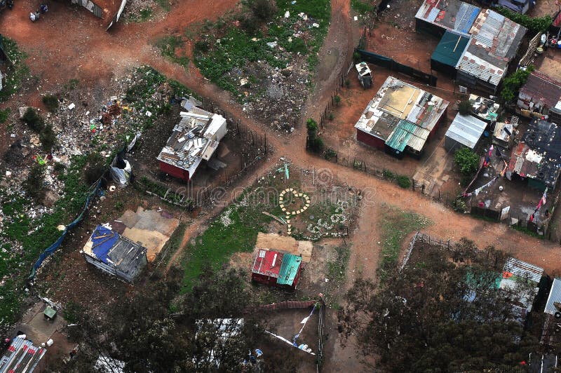 Aerial view of an impoverished area, shanty town or informal settlement. One home owner has laid stepping stones in the shape of a heart in his garden. Among the hardship there is still love.