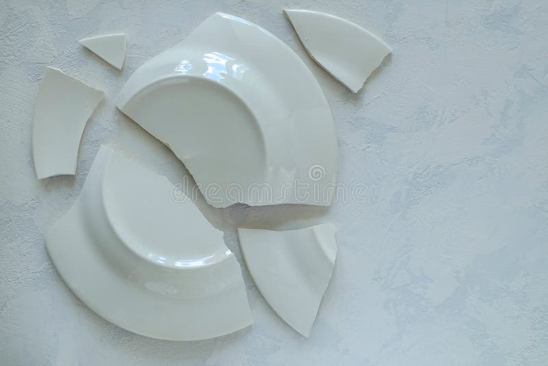 Shards of Broken White Porcelain Plate on a Light Surface Stock Image