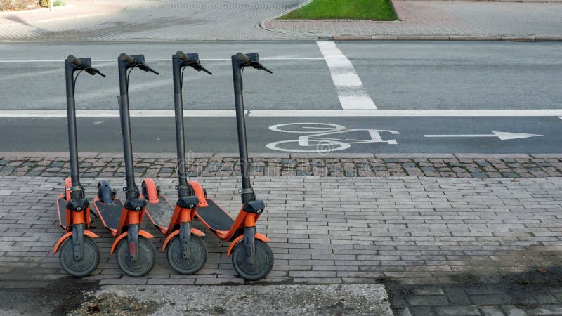 Shared rental electric scooters next parked next to the bicycle road, new trendy gadget for urban young people lifestyle