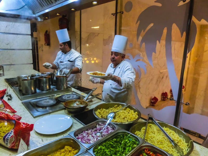 Sharm el Sheikh, Egito - 31 de dezembro de 2018: Posição egípcia do cozinheiro no restaurante do hotel fotos de stock Sharm el Sheikh, Egito - 31 de dezembro de 2018: Posição egípcia do cozinheiro no restaurante do hotel fotos de stock