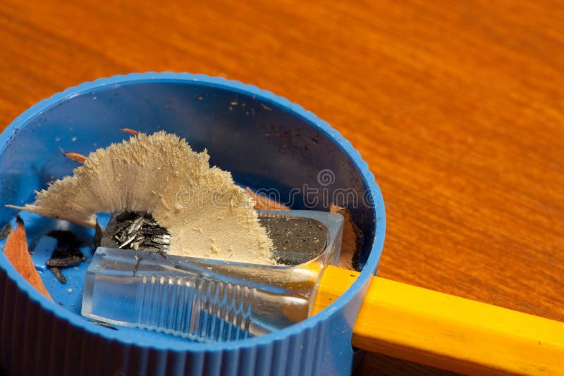 Single yellow pencil in a small pencil sharpener. Single yellow pencil in a small pencil sharpener