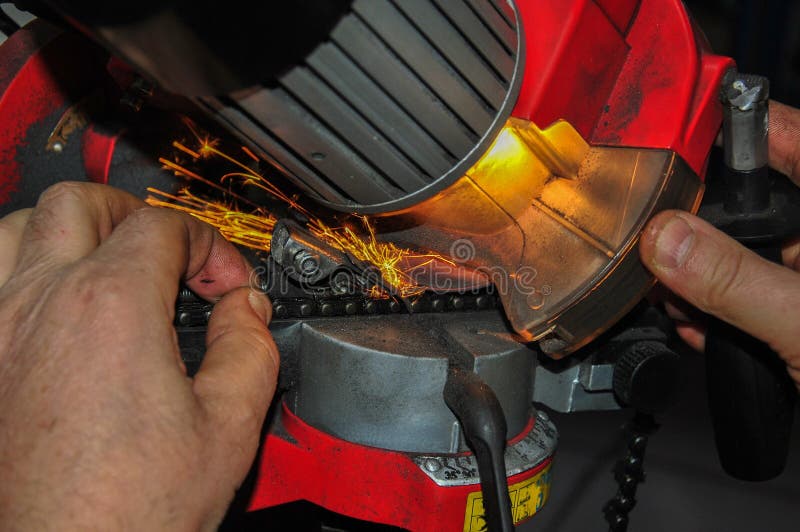 Sharpening a Chainsaw Chain on an Electric Grinder. Stock Photo Image