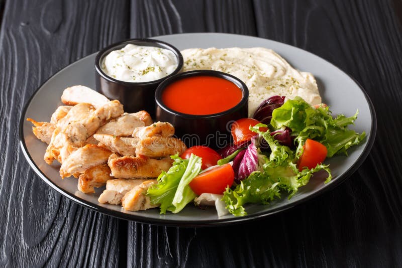 Shawarma bunke med höna, hummus, nya grönsaker sallad och såsnärbild horisontal royaltyfri fotografi Shawarma bunke med höna, hummus, nya grönsaker sallad och såsnärbild horisontal royaltyfri fotografi