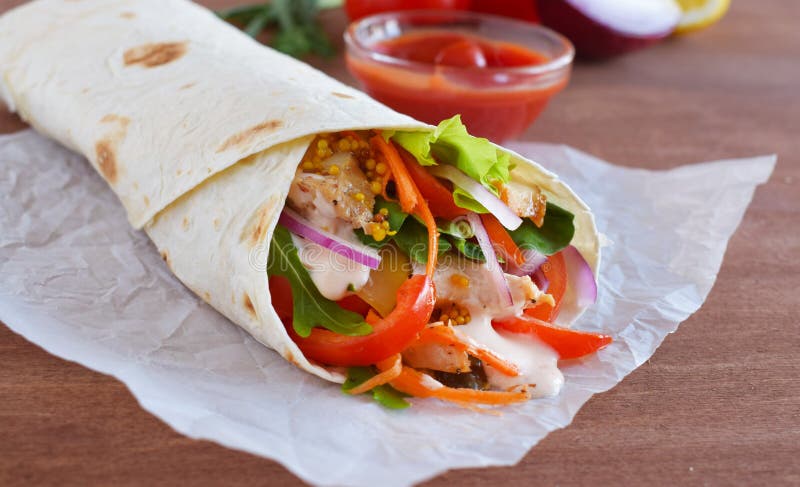 Shawarma caseiro com a faixa da carne da galinha e os legumes frescos sobre a placa de madeira Processo de cozimento foto de stock royalty free Shawarma caseiro com a faixa da carne da galinha e os legumes frescos sobre a placa de madeira Processo de cozimento foto de stock royalty free