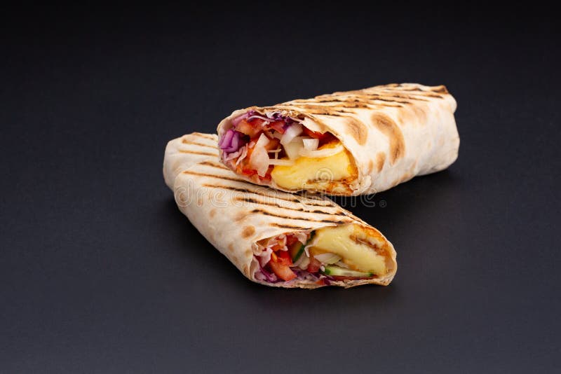 Shawarma in pane della pita è tagliato e si trova su un fondo riflettente nero Il piatto del Medio-Oriente è preparato sul fotografia stock Shawarma in pane della pita è tagliato e si trova su un fondo riflettente nero Il piatto del Medio-Oriente è preparato sul fotografia stock