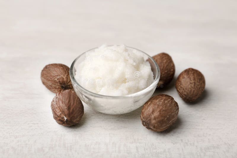 Shea butter in bowl and nuts stock photo