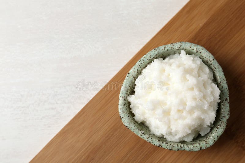 Shea butter in bowl on wooden board, top view stock photos