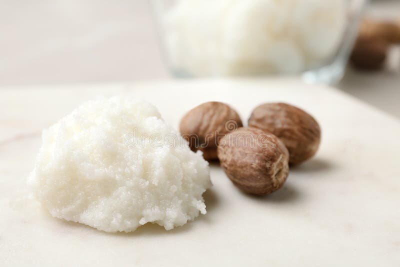 Shea butter and nuts on marble board royalty free stock images
