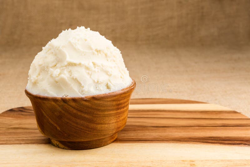 Shea butter in the wooden bowl stands on the wooden board, on th. Unrefined, organic Shea butter in the wooden bowl, stands on the wooden board, jute fabric royalty free stock images Shea butter in the wooden bowl stands on the wooden board, on th. Unrefined, organic Shea butter in the wooden bowl, stands on the wooden board, jute fabric royalty free stock images