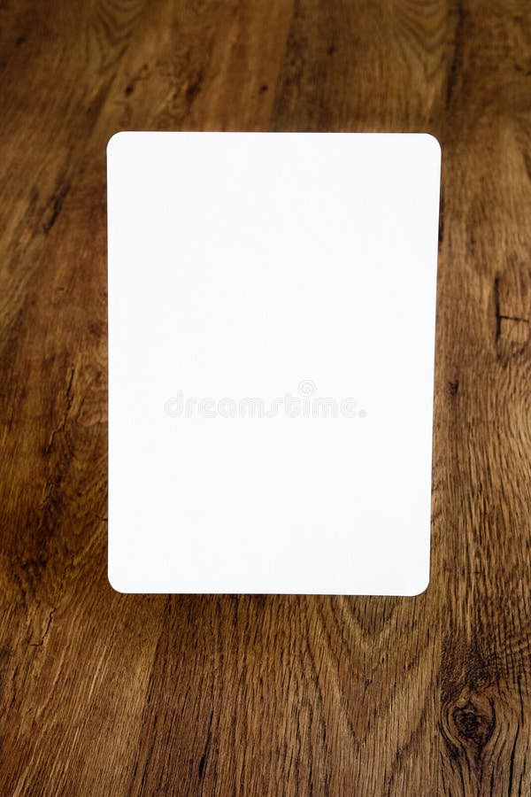 White sheet of paper with rounded borders above the old wooden background, open aperture
