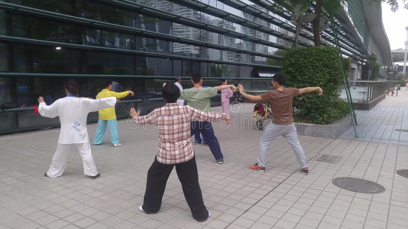 Shenzhen, China: os homens e as mulheres aprendem o qui da TAI, a fim reforçar o corpo