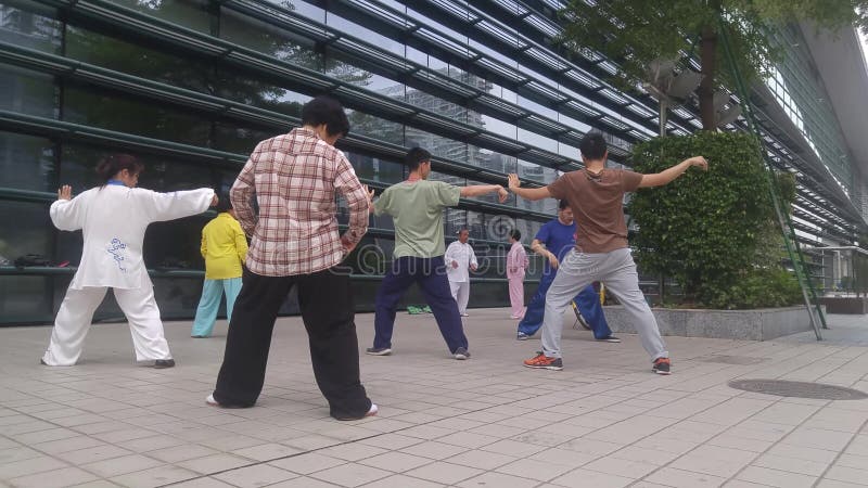 Shenzhen, China: os homens e as mulheres aprendem o qui da TAI, a fim reforçar o corpo