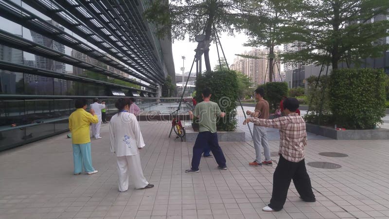 Shenzhen, China: os homens e as mulheres aprendem o qui da TAI, a fim reforçar o corpo