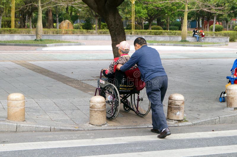 Shenzhen, China: os homens empurraram a cadeira de rodas
