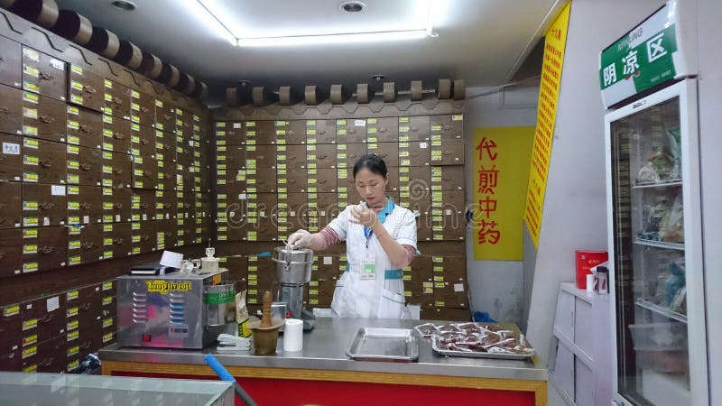 Shenzhen Kina: Kvinnliga apotekare som trycker på mediciner vid maskinen fotografering för bildbyråer Shenzhen Kina: Kvinnliga apotekare som trycker på mediciner vid maskinen fotografering för bildbyråer