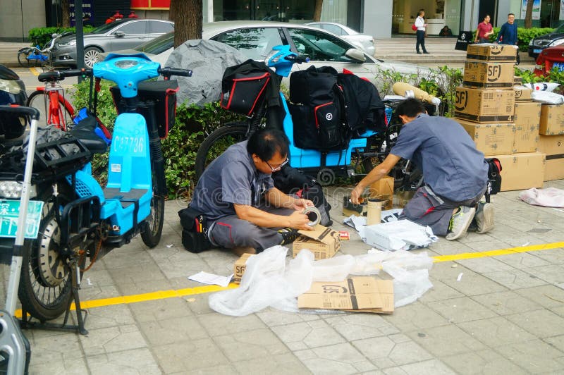 Shenzhen, Κίνα: στην επιχείρηση αγγελιαφόρων πεζοδρομίων οι υπάλληλοι διανέμουν τον αγγελιαφόρο πελατών στοκ εικόνες