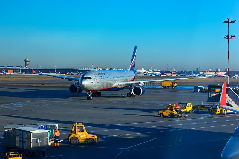 Sheremetyevo, Moscow, Russia. 12/04/2019. Unfocused Plane rides on the runway. Ground service personnel are waiting for it.