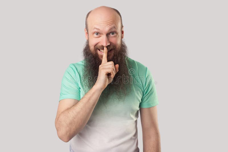Shh das ist geheim. Porträt von zahnhaften Smiley mittleren Alters kahlen Mann mit langem Bart in hellgrünen T-Shirt mit Finger au