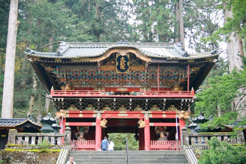 A shinto priest sweeps under the Yomeimon gate at Nikko, Japan stock image A shinto priest sweeps under the Yomeimon gate at Nikko, Japan stock image