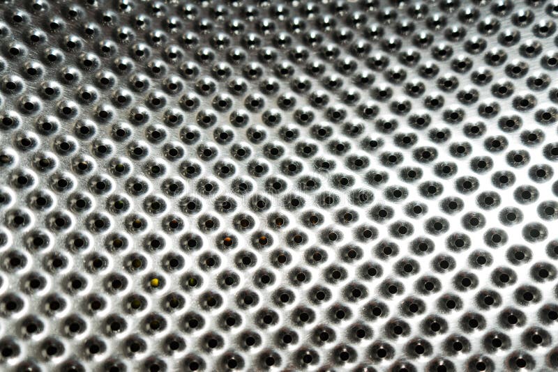 Shiny metal surface with perforation. Fragment of the washing machine drum royalty free stock photography