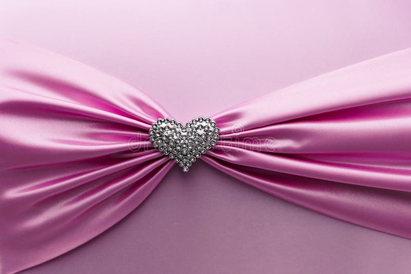 Shiny pink satin ribbon and diamond heart .