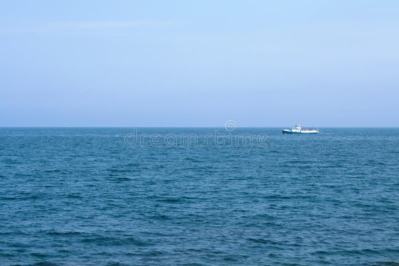 Ship on blue sea horizon