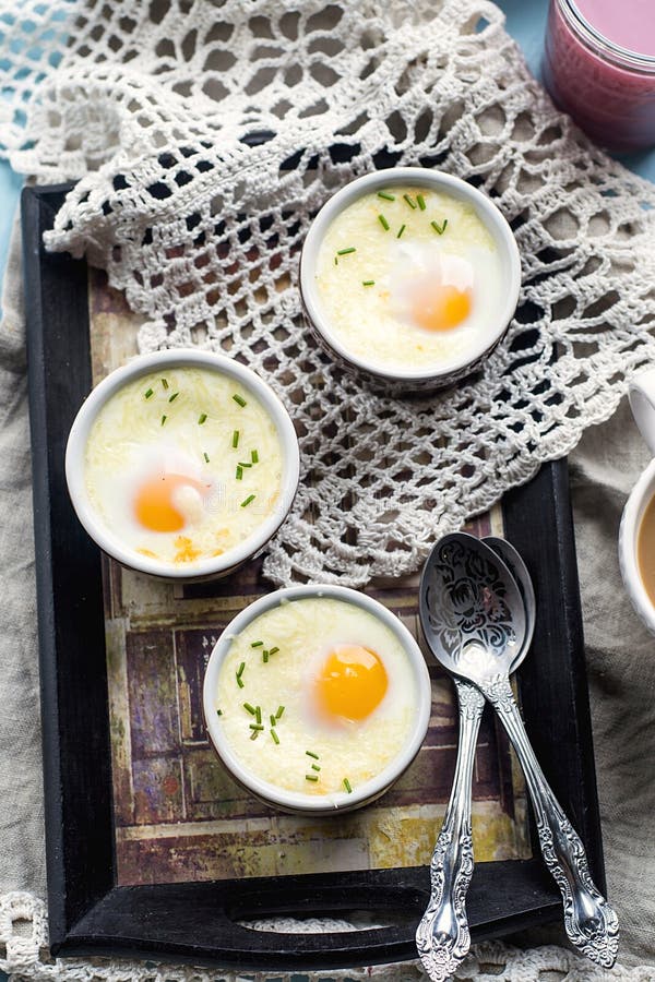 Shirred baked eggs for breakfast with coffee. Shirred baked eggs for breakfast with coffee