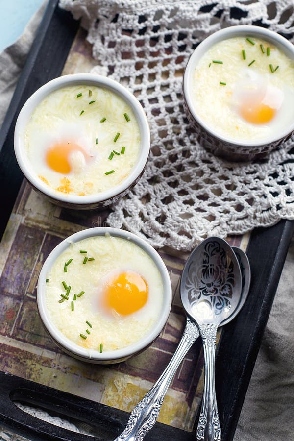 Shirred baked eggs for breakfast with coffee. Shirred baked eggs for breakfast with coffee