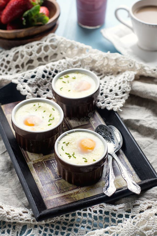 Shirred baked eggs for breakfast with coffee. Shirred baked eggs for breakfast with coffee