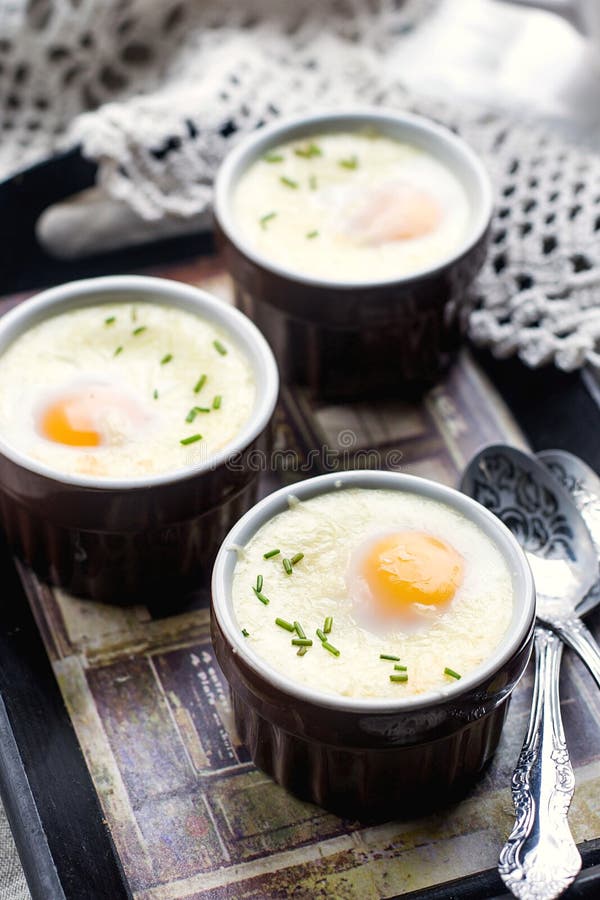 Shirred baked eggs for breakfast with coffee. Shirred baked eggs for breakfast with coffee