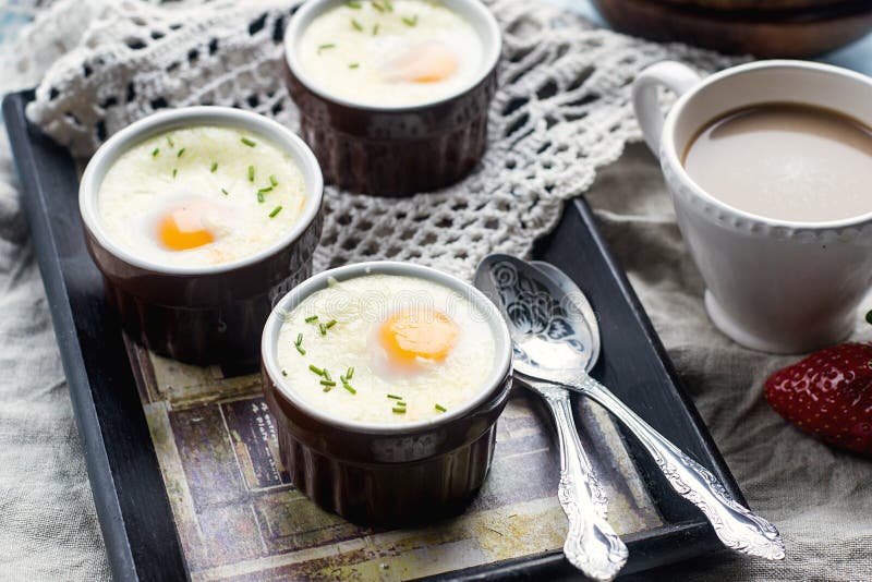 Shirred baked eggs for breakfast with coffee. Shirred baked eggs for breakfast with coffee