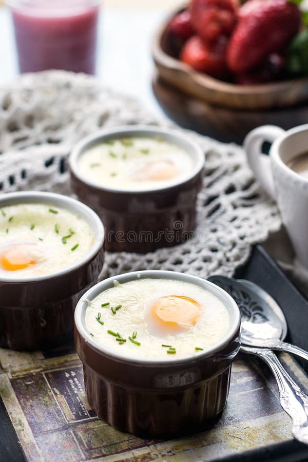 Shirred baked eggs for breakfast with coffee. Shirred baked eggs for breakfast with coffee