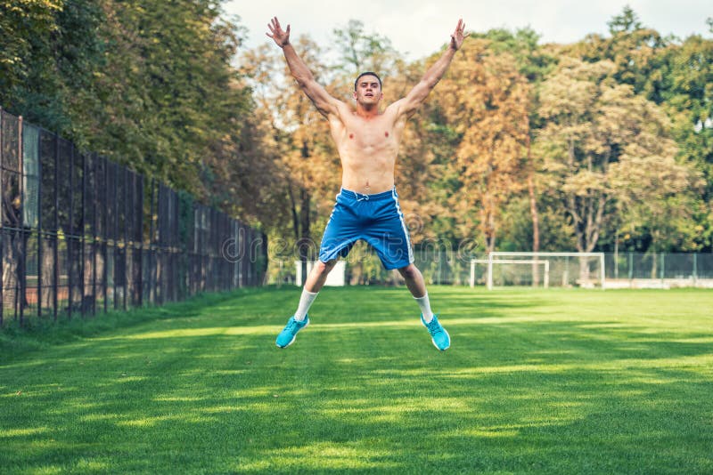 Shirtless knappe mens die in park, dwars geschikte opleiding uitwerken Atletische mens die en oefeningen springen doen openlucht