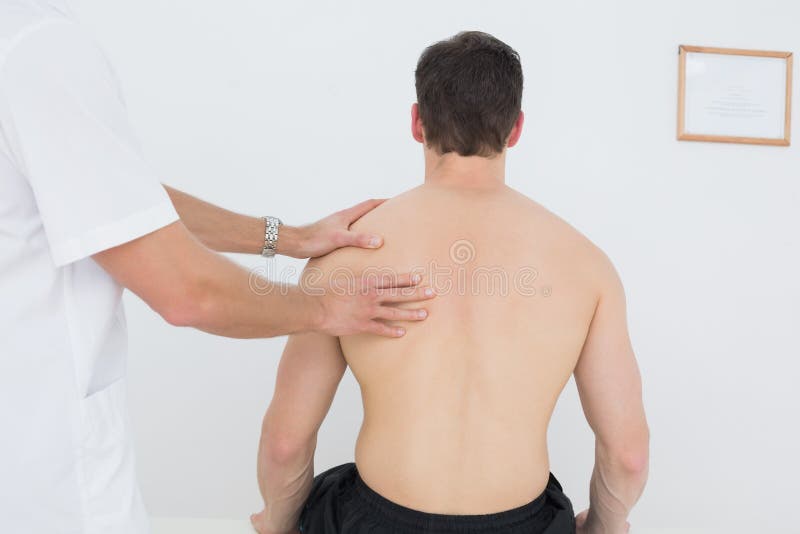 Shirtless man being massaged by a physiotherapist stock image