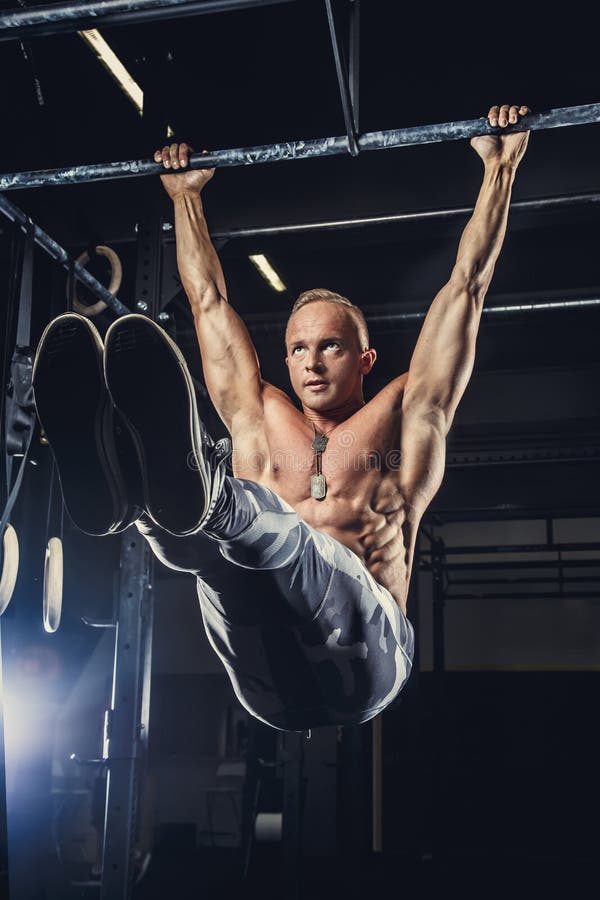 Shirtless man som gör övningar på horisontalstång arkivbild Shirtless man som gör övningar på horisontalstång arkivbild