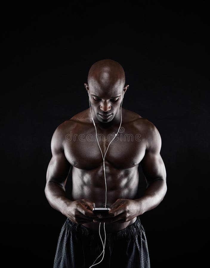 Shirtless young man listening music on mobile phone