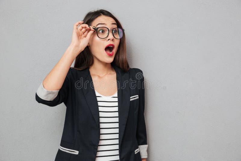 Shocked business woman in eyeglasses looking away with open mouth stock photo Shocked business woman in eyeglasses looking away with open mouth stock photo