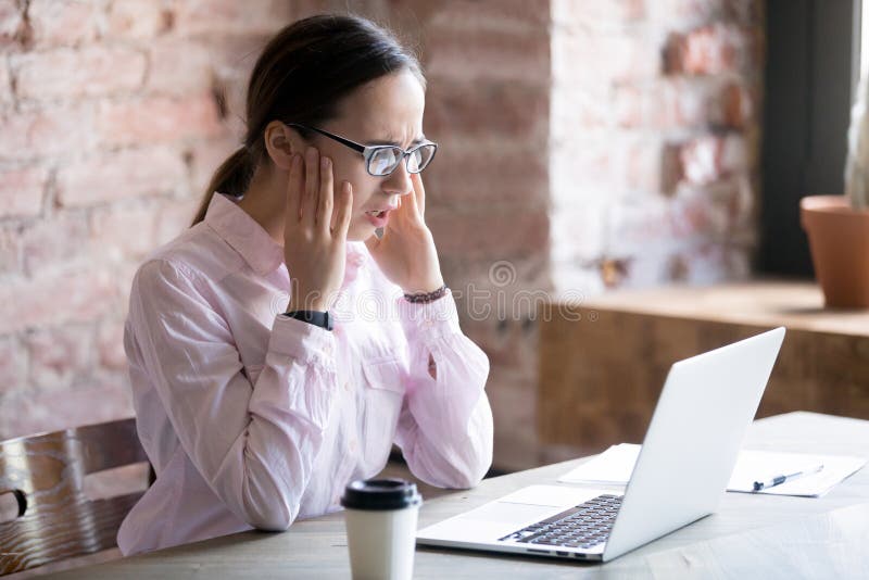 Shocked businesswoman looking at laptop screen with fear. royalty free stock photography
