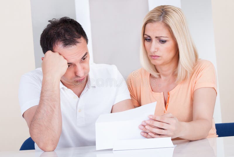 Shocked couple looking at bill royalty free stock image