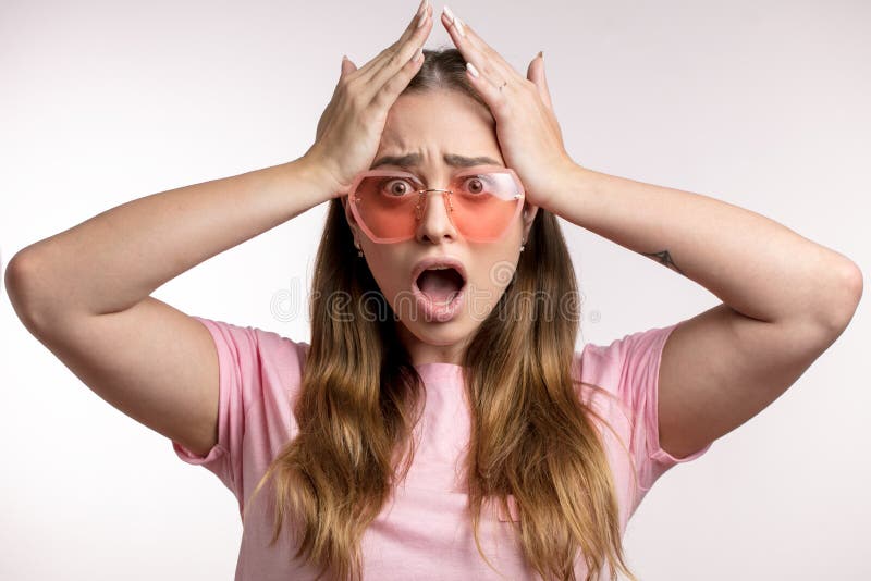 Shocked crazy woman in stylish sunglasses is holding her head. stock photography