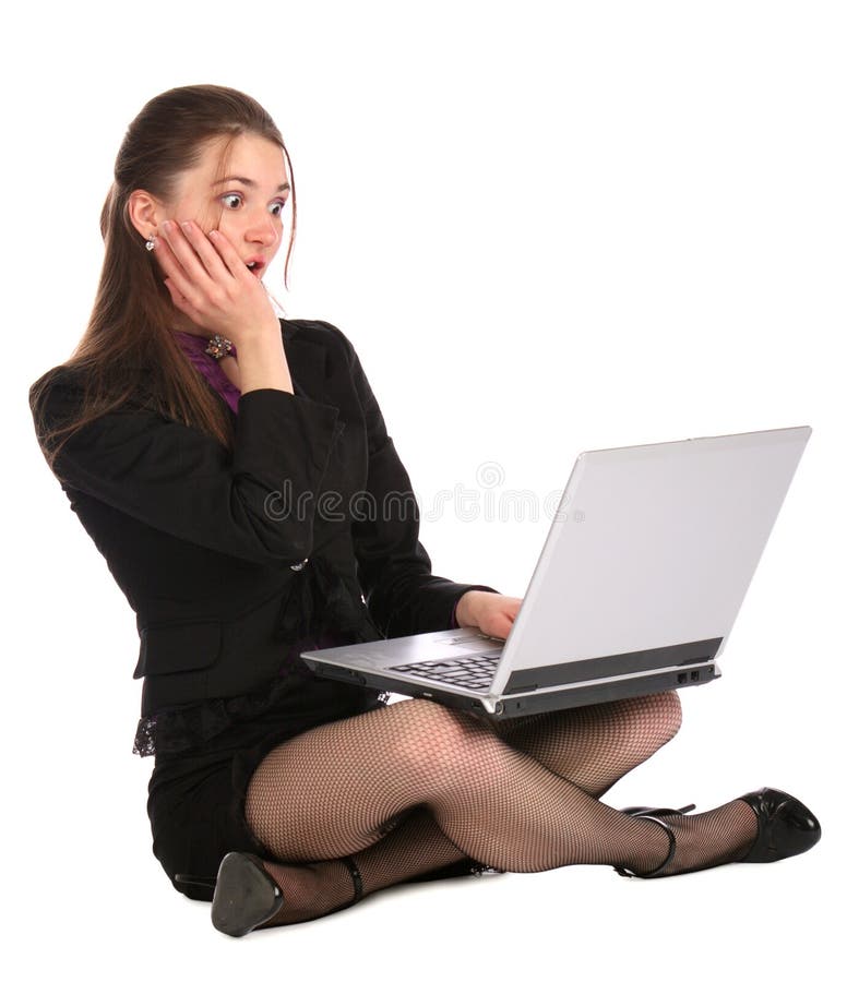 Shocked girl sits on floor with notebook.